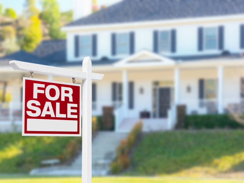 house with sign for sale in yard